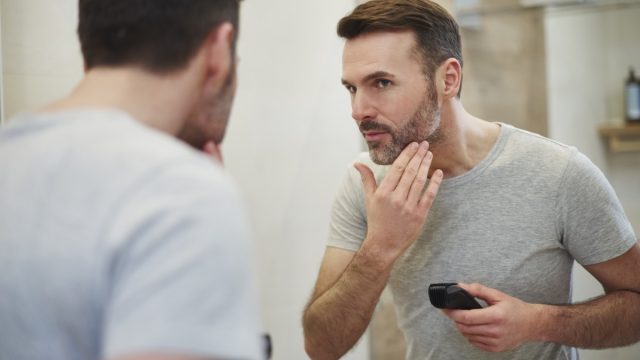 Mature man with electric razor shaving