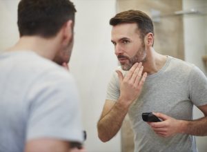 Mature man with electric razor shaving