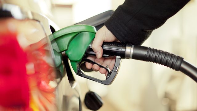 hand pumping gas at gas station