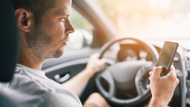 Driver using his mobile phone whilst driving a car