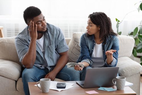ouple accounting family budget at home, wife scolding her husband for overspending and lack of money
