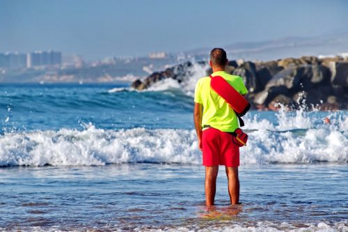 lifeguard standing in the water at the beach