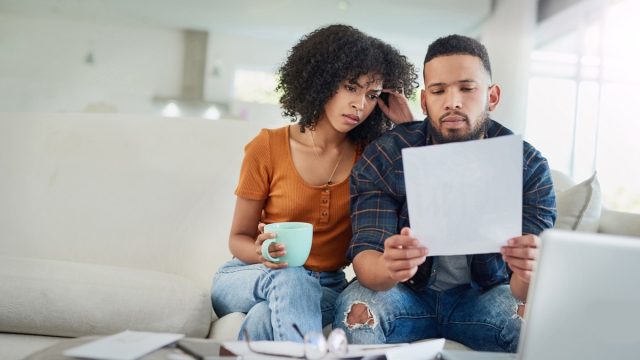Shot of a young couple looking stressed while going over their finances at home