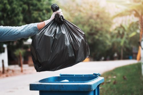 gloved-hand-throwing-away-trash