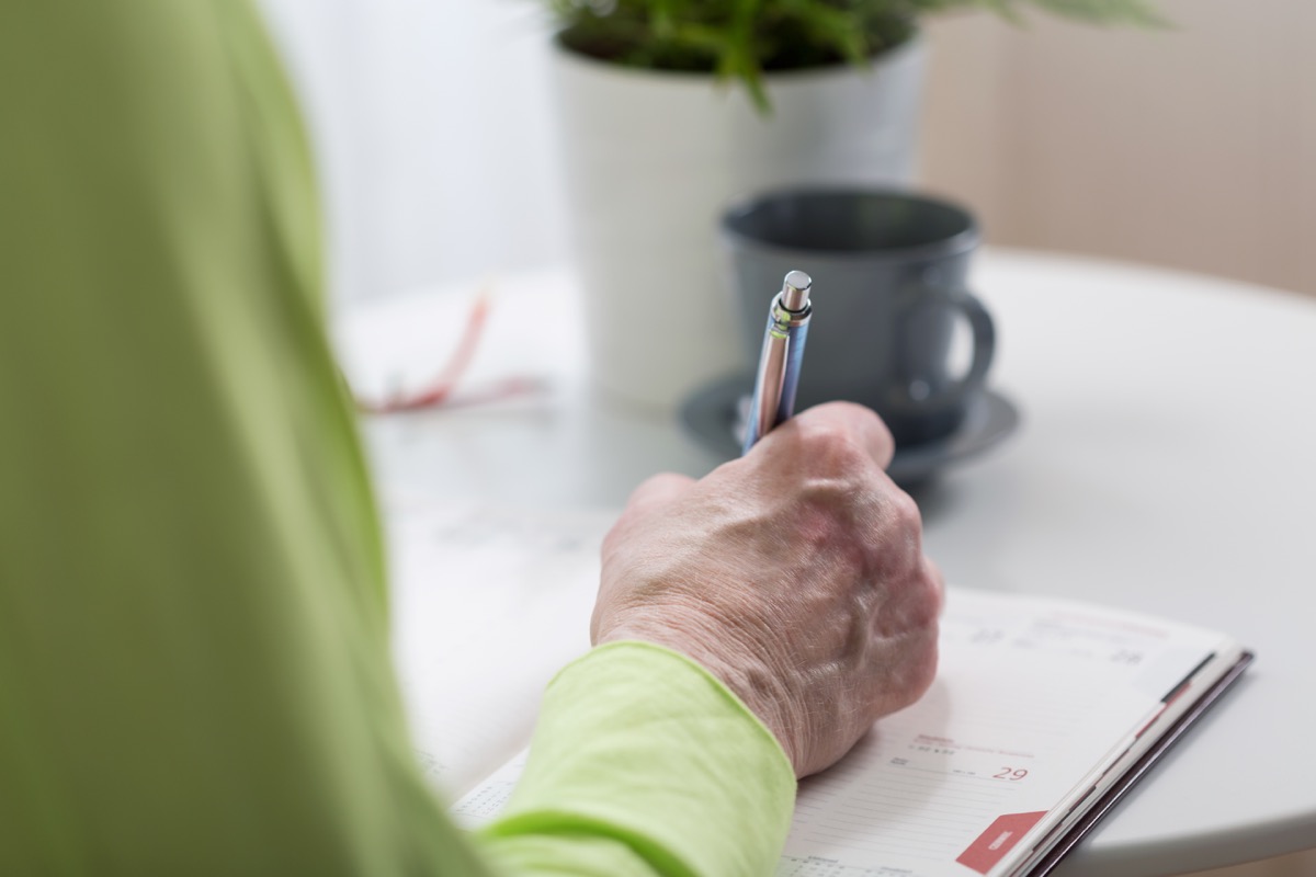 Older person writing on paper