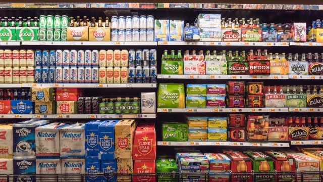 Various bottles of craft, microbrews, IPAs, bitter, ale, wheat, domestic and imported beer styles from around the world on shelf display in store.