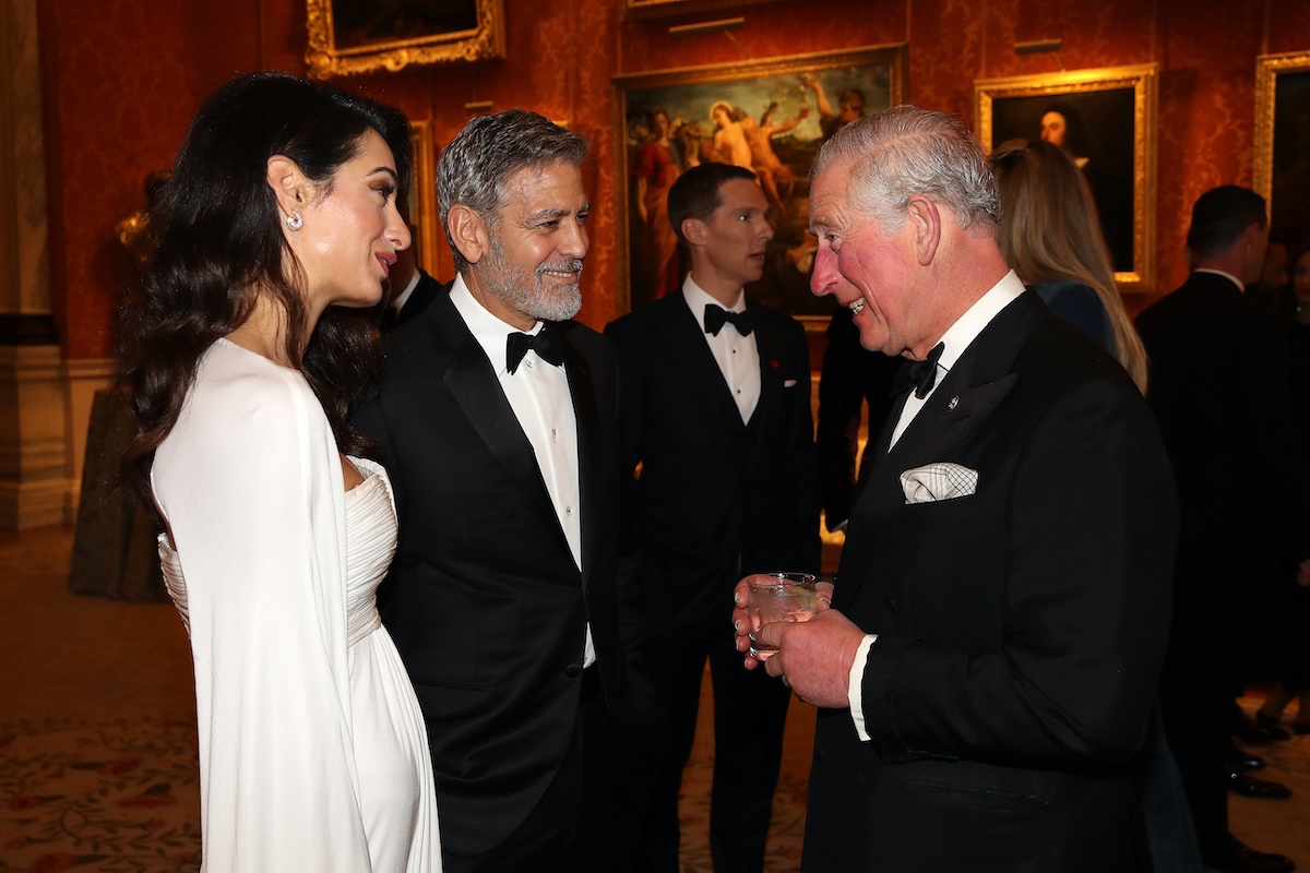 Amal Clooney and George Clooney speak to Prince Charles, Prince of Wales as they attend a dinner to celebrate The Prince's Trust, hosted by Prince Charles, Prince of Wales at Buckingham Palace on March 12, 2019 in London, England.