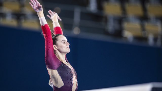 Olympic gymnast Pauline Schäfer in action on beam in a unitard.