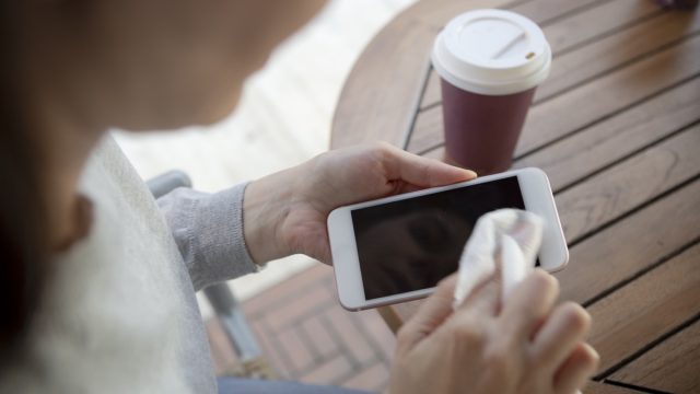 Female hands wipe the touch screen phone antibacterial wipes