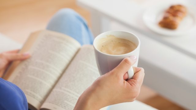woman drinking coffee and reading