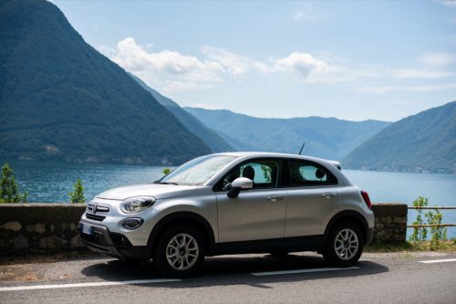 a white Fiat 500X car next to a mountain