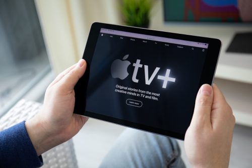Man holding iPad with Apple TV+ app