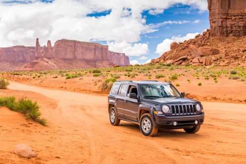 A black Jeep Patriot car driving off road