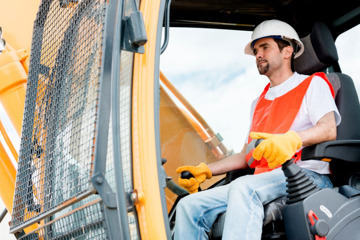 30-something man operating crane