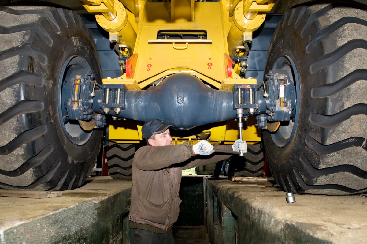 mechanic fixing tractor