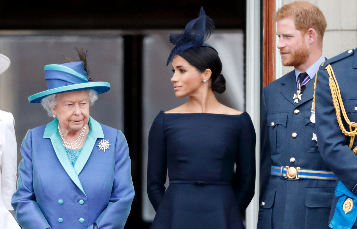 Queen Elizabeth II, Meghan, Duchess of Sussex and Prince Harry, Duke of Sussex watch a flypast to mark the centenary of the Royal Air Force from the balcony of Buckingham Palace on July 10, 2018 in London, England.