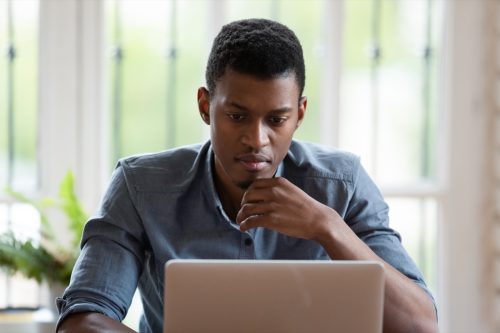 millennial male employee look at laptop screen working
