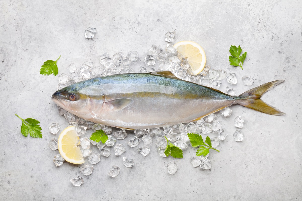 Raw, whole fish on bed of ice and lemons