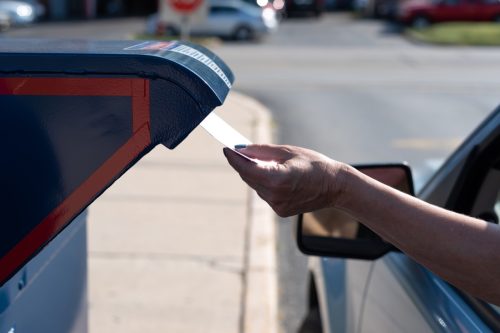 Palatine, IL/USA - 08-27-2020: Safely mailing an application for ballot for 2020 election at a drive-up mailbox at the US Post Office