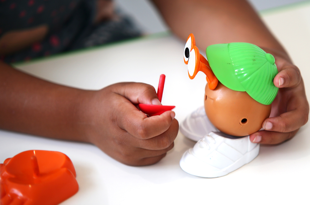 A child playing with a Potato Head toy