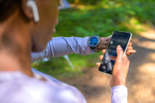 woman using tracker software on smartphone and smartwatch. Modern technology and healthy lifestyle concept.