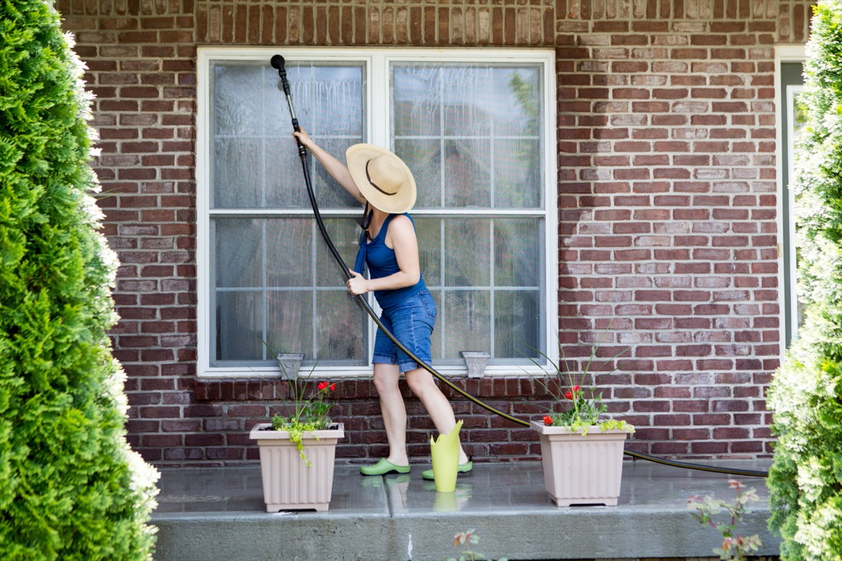 woman spraying window with hose