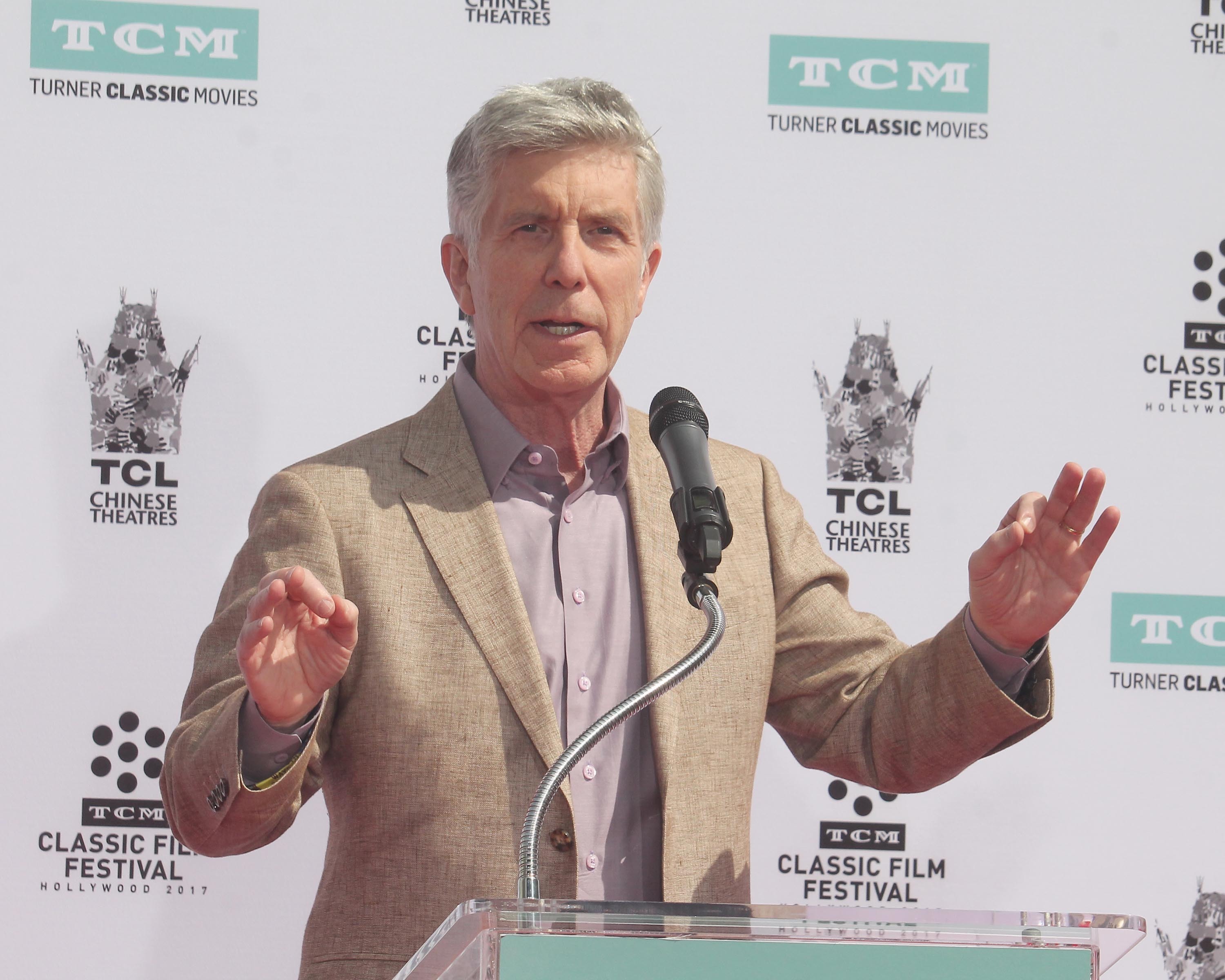 TV host Tom Bergeron speaking at a podium.