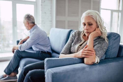 older couple sitting on couch arguing