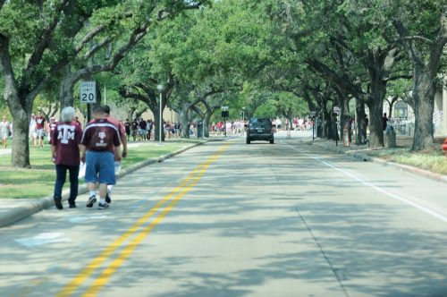 College Station, Texas, USA - September 14, 2013: Fans walking along road to the stadium on campus of Texas A&M University in College Station, Texas. Fans attending game between Texas A&M and The University of Alabama. Photo take before game time.