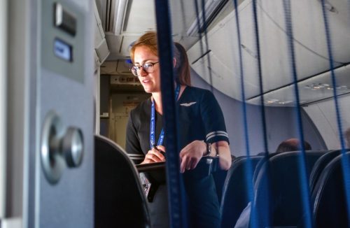 untied flight attendant helping passengers