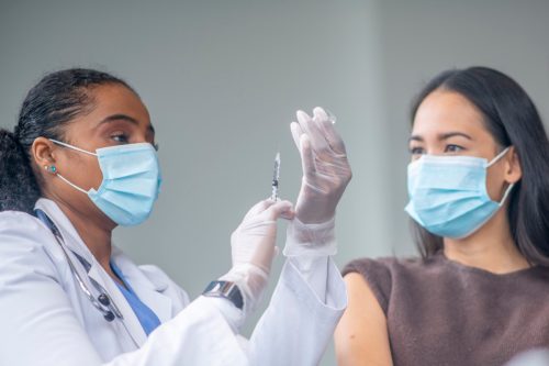 Doctor Preparing a Patients Vaccine Syringe