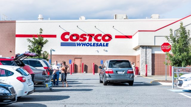 People with shopping carts filled with groceries goods, products walking out of Costco store in Virginia in parking car lot