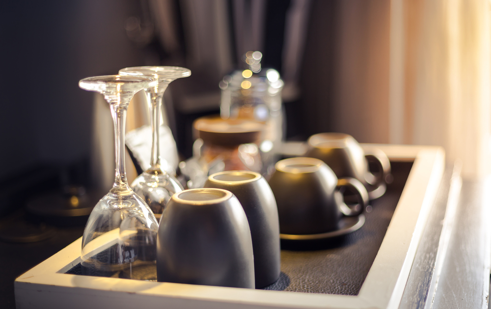 Wine glasses, coffee cups, and water glasses in a hotel room
