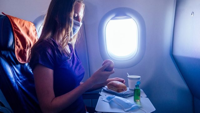 Passenger looking down at food on airplane