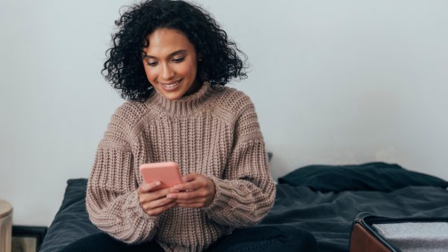 Young woman on phone texting at home