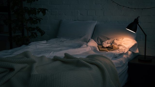 Interior,Of,Bedroom,With,Book,And,Glasses,On,Empty,Bed,