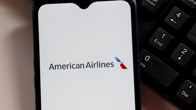 The American Airlines logo on a smartphone screen sitting next to a keyboard