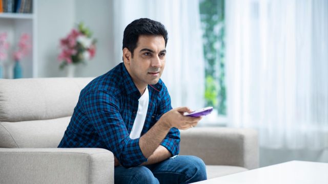 Young man at home sofa sitting - stock photo