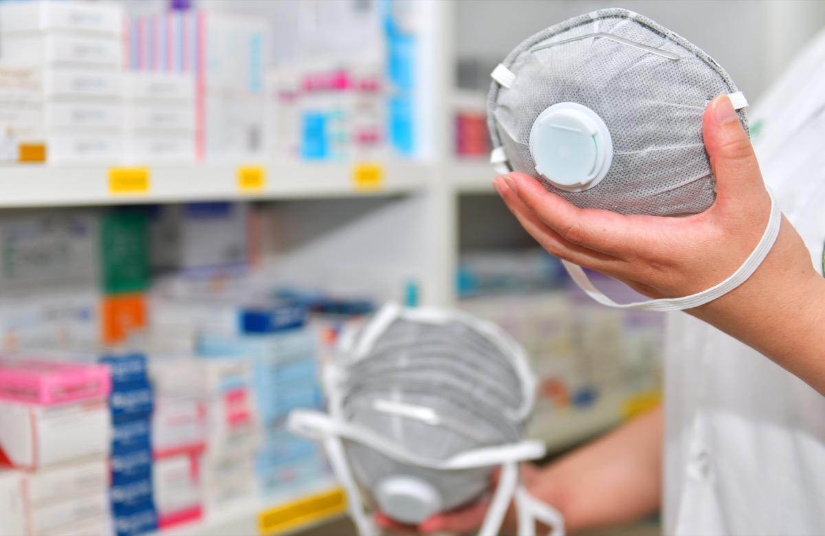 Pharmacist hand holding N95 mask in pharmacy drugstore