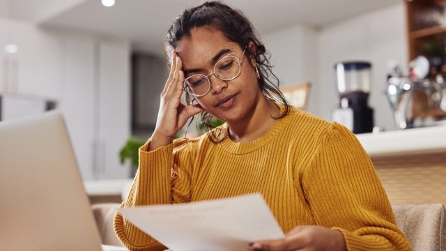 Shot of a cafe owner looking stressed while looking at paperwork