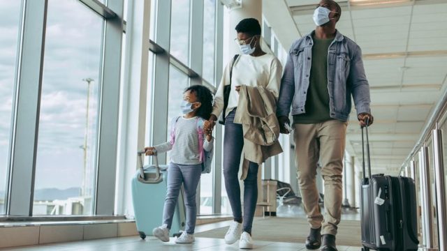 A family boarding a flight with their carry on luggage