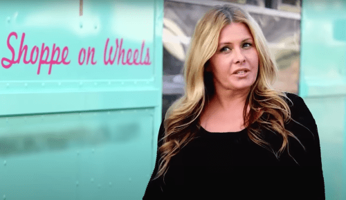 Nicole Eggert standing next to her ice cream truck in a video from "Where Are They Now?"