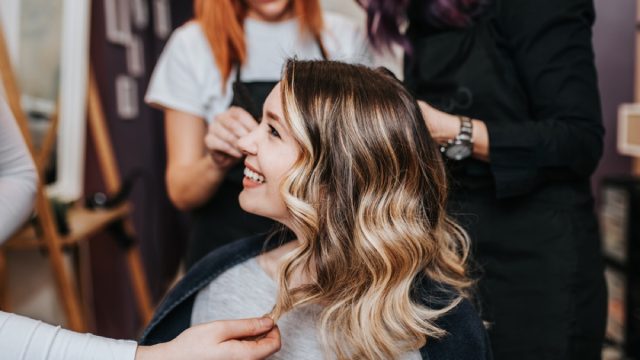 woman with highlights smiling after getting her hair dyed