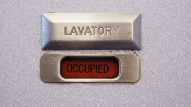 A lavatory sign on a plane bathroom door that says "occupied"