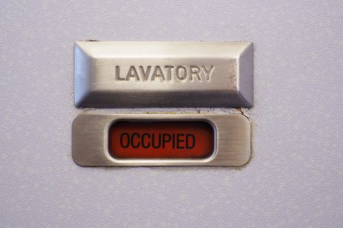 A lavatory sign on a plane bathroom door that says "occupied"