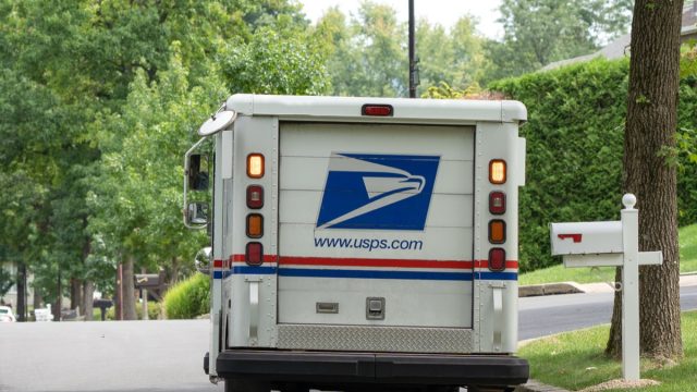 USPS truck delivering mail on suburban street in Pennsylvania.