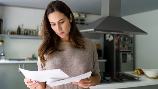woman at home checking her mail - domestic life concepts