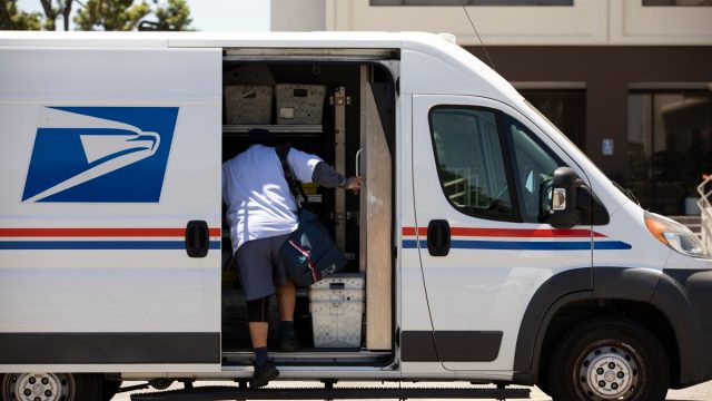 A USPS Postal worker delivers mail.