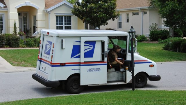 USPS mail carrier delivering mail