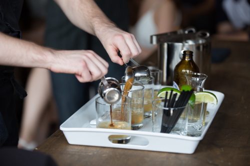 close up on instructor pouring cocktails in mixology class
